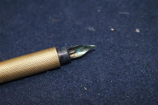 An Edwardian engine turned yellow metal fountain pen, with engraved inscription, 12.6cm.